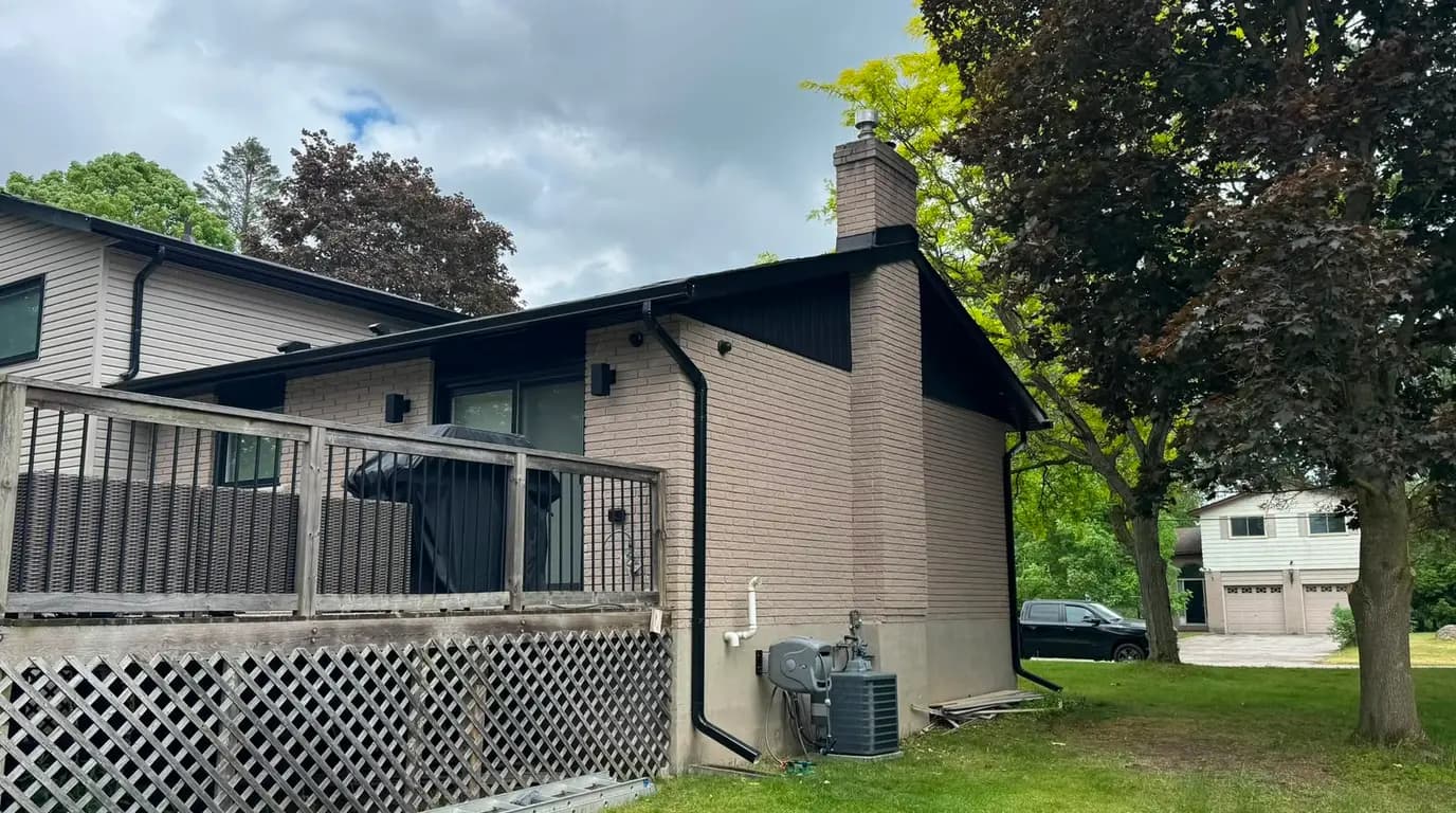 The same house before the work, with the original cladding on the upper storey and gable and a wooden deck across the back