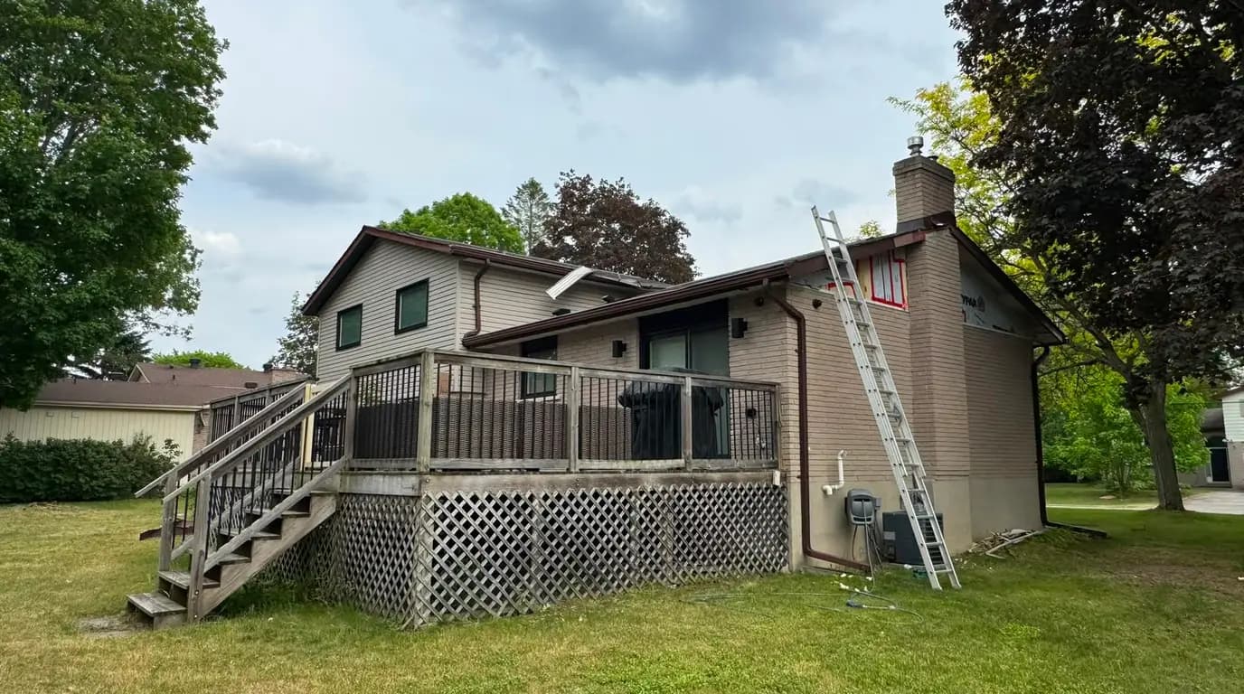 Ladder against the finished upper storey part way through the job, with the deck and the original brick below