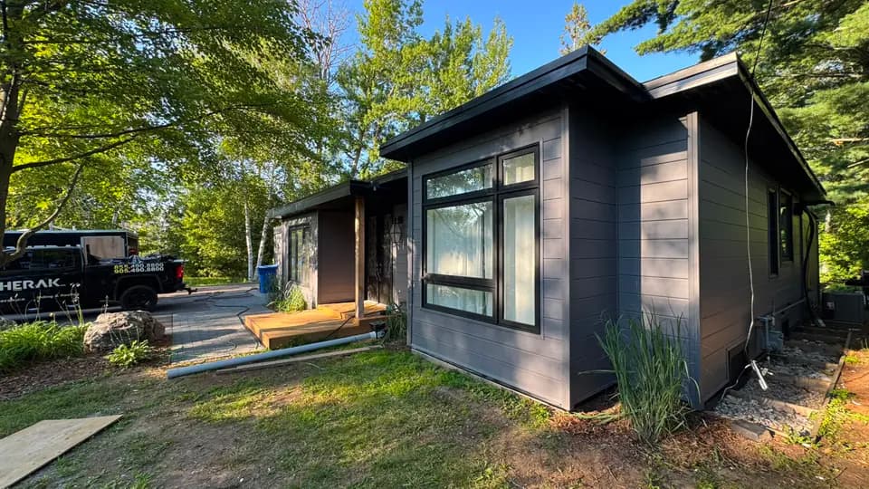 Lakefront home with charcoal plank siding, black fascia and a new eavestrough line, Jackson's Point